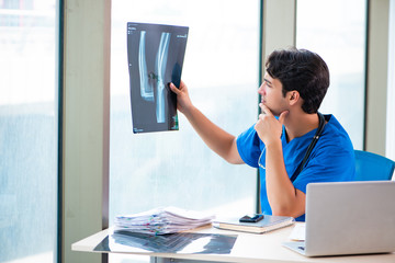 Young handsome doctor working in the hospital 