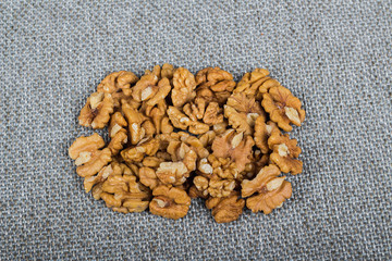 whole walnuts and kernels on burlap background, healthy food