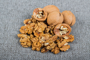 whole walnuts and kernels on burlap background, healthy food