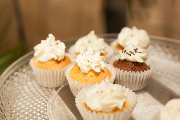 Bakery. Stock of Muffins covered with cream.