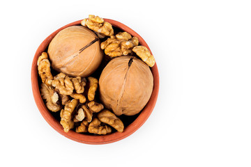 walnut kernels isolated on white background, in ceramic pot
