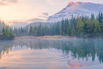 Golden yellow sky of morning sunrise with water refelction of Cascade pond in Banff National park