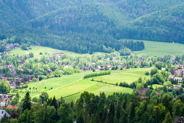 The landscape seen from Gubałówka in Poland in the summer season. Beautiful green natural vegetation and houses inhabited by people.