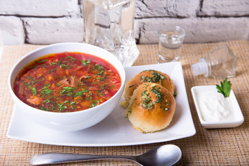 Borscht/borsch. Traditional Russian and Ukrainian soup. Buns with garlic. Close-up, selective focus.