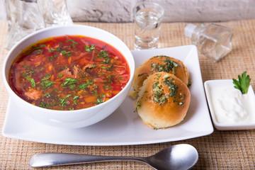 Borscht/borsch. Traditional Russian and Ukrainian soup. Buns with garlic. Close-up, selective focus.