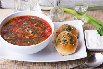 Borscht/borsch. Traditional Russian and Ukrainian soup. Buns with garlic. Close-up, selective focus.
