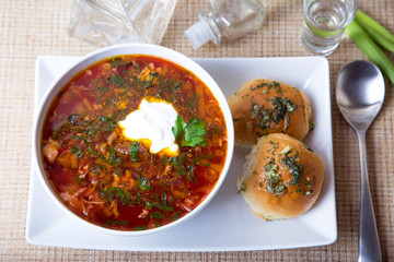 Borscht/borsch. Traditional Russian and Ukrainian soup. Buns with garlic. Close-up, selective focus.