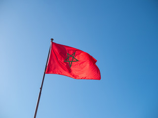 Morrocan flag on flag pole against blue sky