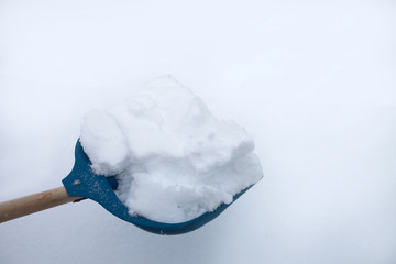 Cleaning snow with shovel in winter day