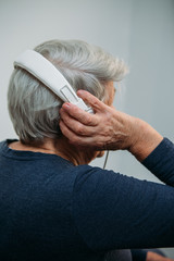 Naklejka premium This song takes her back. old women with headphones