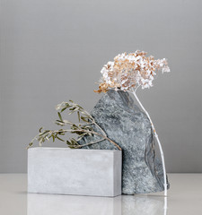 Art installation using concrete blocks, golden plants and natural stone.