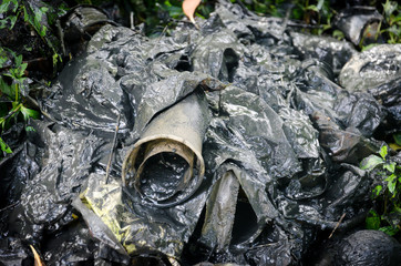 Plastic and other rubbish discarded in polluted muddy water