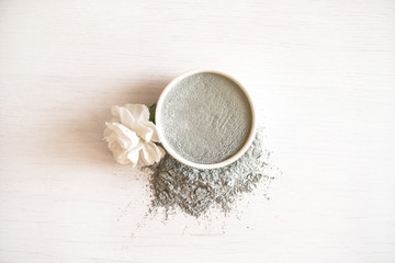 Blue cosmetic clay on white wooden background.