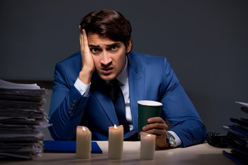 Businessman working late in office with candle light