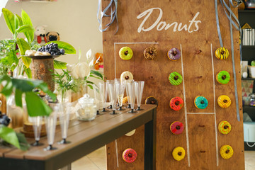 assortment of colorful fresh donuts on a wooden Board for the holiday