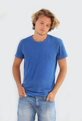 Portrait of attractive teenage boy standing in front of a gray wall.