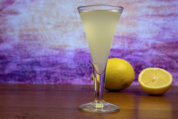 Lemoncello (Italian lemon liqueur) in a glass close-up and lemons