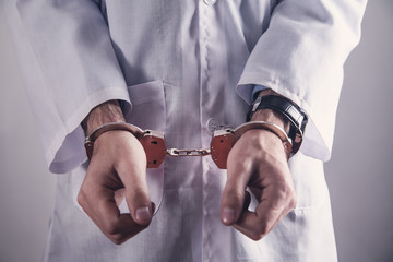 Doctor with handcuffs. Medical crime