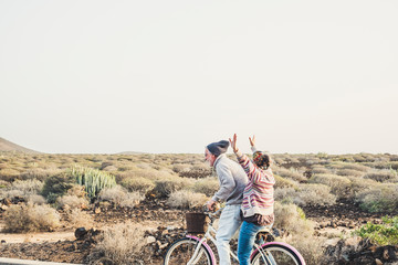 Caucasian aged mature couple have a lot of fun riding together the same bike in outdoor happy...