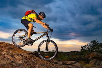 Fototapeta na wymiar Cyclist Riding the Mountain Bike on Rocky Trail at Sunset. Extreme Sport and Enduro Biking Concept.
