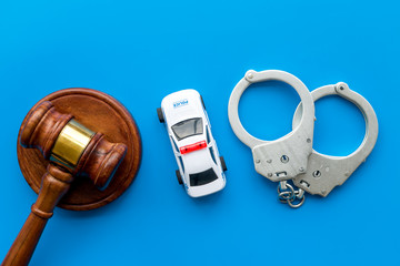 Crime concept. Police car toy, handcuff, judge hammer on blue background top view