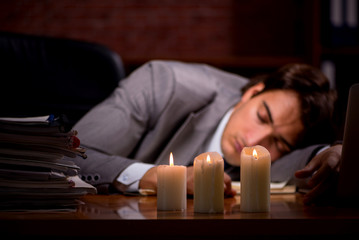 Businessman working late in office with candle light