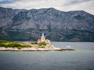 Ferry passing close to Sucuraj lighthouse on Hvar island, Croatia