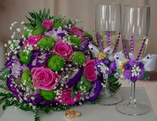 Horizontal shot of wedding rings with a bouquet of the bride and glasses of champagne. The concept of a wedding day