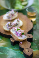 Open sandwiches with atlantic herring and red onions and a glass of vodka. Smorgasbord -...
