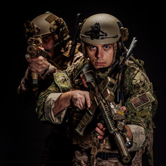 soldiers or private military contractors holding rifle. Image on a black background. war, army, weapon, technology and people concept