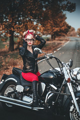 Plakat Beautiful biker woman posing outdoor with motorcycle. Pin-up style. 