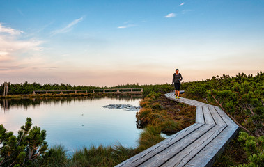 woman walking on wooden path in nature
