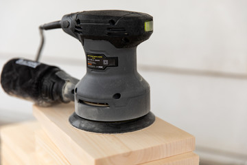 Electric sander on wood planks