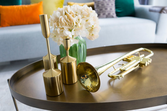 colorful and stylish living room with flower vase and gold trumpet on table. 