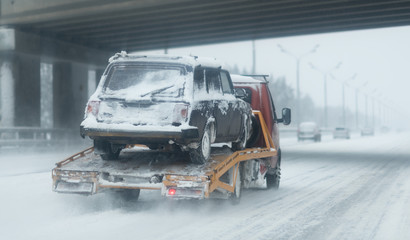 Truck with a car after road accident. Highway with a lot of snow after blizzard - 245749999