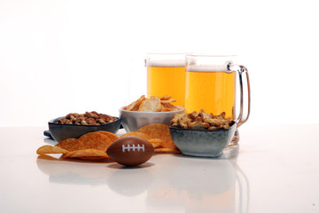 Chips, salty snacks, football and Beer on a table. Great for Bowl Game projects.
