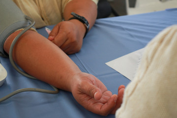 Volunteer checking man Risk group arterial blood pressure. Health care.