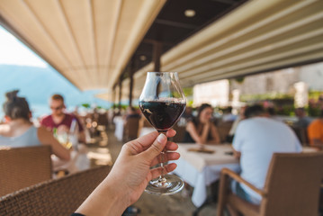 woman hand holding glass of red wine