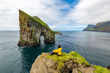 Drangarnir rocks at Faroe Islands, Europe. Hiker admiring the view