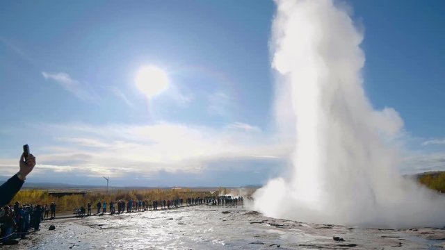 A crowd admiring an eruption of Stokkur geyser on Iceland