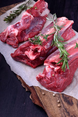 Raw beef ribs, rosemary, thyme and spices on a wooden board