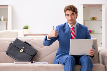 Young businessman working at home sitting on the sofa 