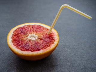 Blutorange halbiert mit Strohhalm