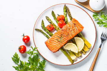 Grilled salmon fish fillet with asparagus on white. 