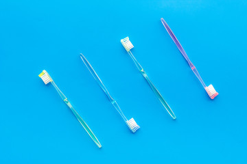 Oral hygiene. Plastic toothbrushes on blue background top view