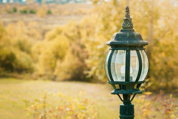 Fototapeta premium Beautiful street lamp to illuminate the street against background of yellow autumn trees.