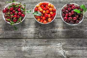 Fresh cherries in a bowl. Red sweet cherry fruit, flat lay, top view.