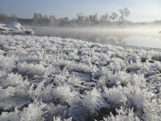 Crystals of snowflakes on the background of a winter landscape with a river.