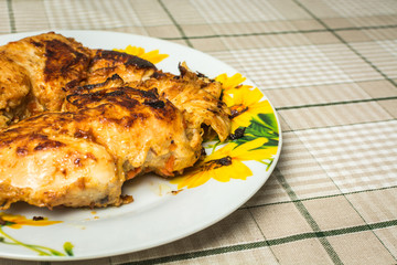 Fragrant fried chicken breast fillet in a plate on the kitchen table.
