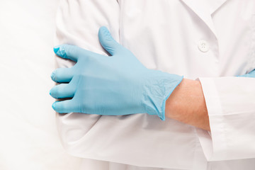 Fototapeta premium man doctor in blue medical gloves on while standing against a white background